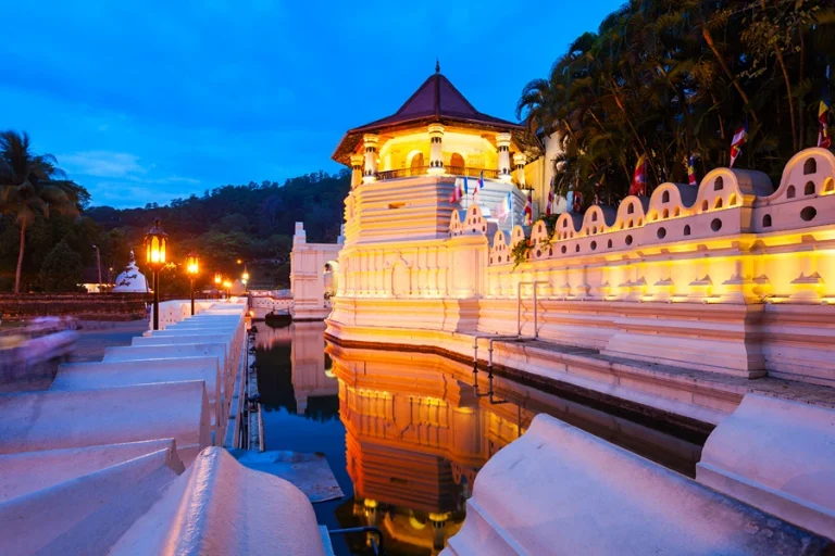 Evening view of the Sri Dalada Maligawa in Kandy, a sacred Buddhist temple glowing with golden lights