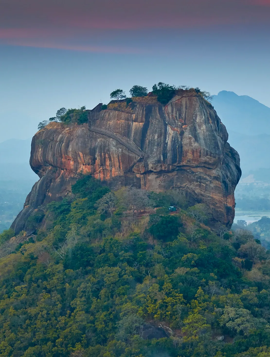 Sunrise over Sigiriya Rock Fortress surrounded by lush jungle, a top destination in Sri Lanka
