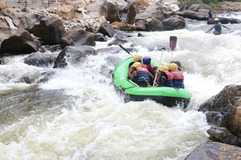 Group of adventurers rafting through rapids on the Kelani River in Kitulgala, surrounded by lush rainforest in Sri Lanka