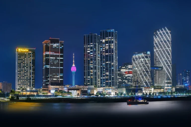 Illuminated skyline of Colombo at night viewed from the sea, with glowing modern buildings in Sri Lanka’s capital